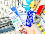 hand holding cerave products over walgreens cart