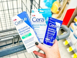 hand holding cerave products over walgreens cart