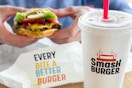 a person holding a burger at smash burger
