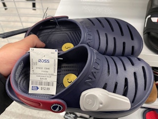 A person's hand holding a pair of Nautica Crocs dupes at Ross.