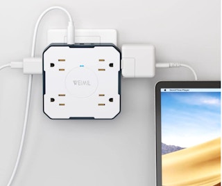 a outlet extender with plugs inside next to a computer on a desk