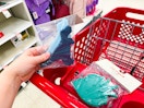 hand holding a kids' dinosaur ice pack set over a target cart