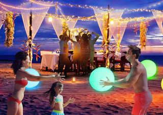 a family playing with glowing beach balls on a beach