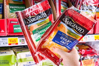 hand holding packs of sargento cheese slices
