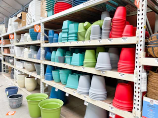 shelf of plastic planters at Home Depot