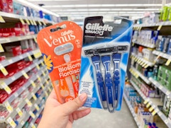 hand holding gillette and venus razors in walgreens
