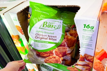 hand holding a bag of just bare chicken
