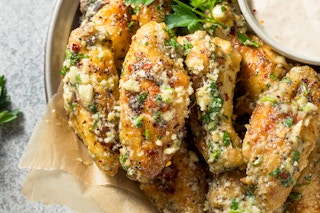 garlic parmesan wings with parsley garnish and dip