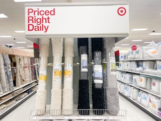 A variety of Room Essentials 4x5 Shag Rugs standing upright on a shelf at Target.