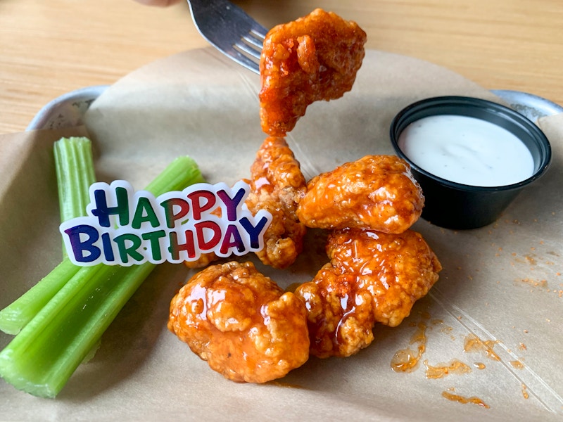 A free Birthday snack size plater of boneless buffalo wings with a plastic Happy Birthday tag on top of it.