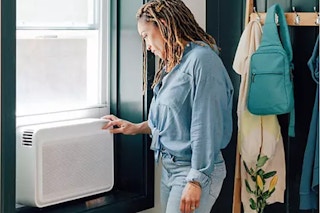 windmill smart a/c unit in a window, being adjusted by a person