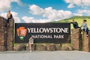 a family posing on the Yellowstone National Park sign