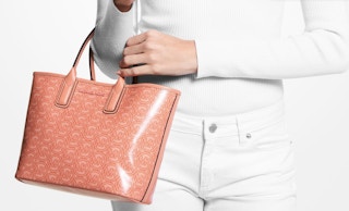 lady holding a coral Michael Michael Kors Jodie Small Logo Jacquard Tote Bag