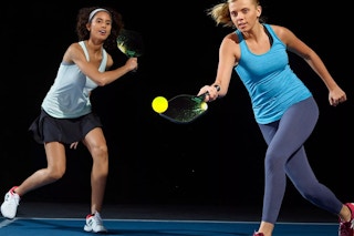 2 women playing pickleball