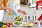 woman making salad with attachment