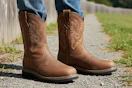lifestyle image of a person standing outside in steel toe cowboy work boots