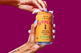 Stock image of the De La Calle Tepache, Mandarin (12 ounce can being opened)