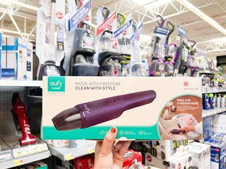 Hand holding a Anker Eufy Cordless Handheld Vacuum in Vacuum aisle at Walmart