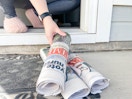 a person grabbing a newspaper from porch