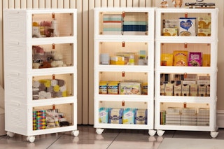 three 4-tier storage bins on wheels with items inside