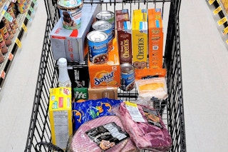 A cart of groceries in a store aisle.
