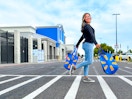 woman crossing the parking lot holding two walmart bags
