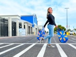 woman crossing the parking lot holding two walmart bags