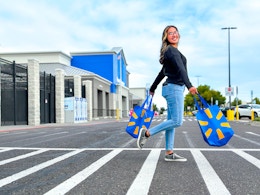woman crossing the parking lot holding two walmart bags