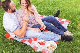 two people sitting on picnic blanket