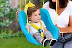 Lifestyle image of a a Baby Shark swing with small child being swing outdoors