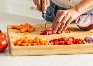 a person chopping on a cutting board
