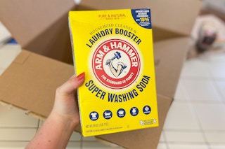 hand holding arm and hammer laundry booster super washing soda in front of an amazon box