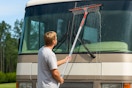man using squeegee tool on RV