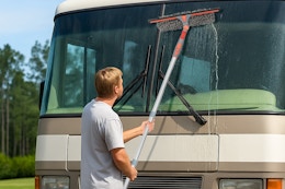 man using squeegee tool on RV