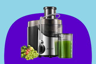 A wide-mouth centrifugal juicer with fruits on one side and green juice on the other