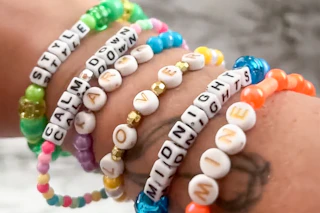 some homemade bead friendship bracelets on a person's arm