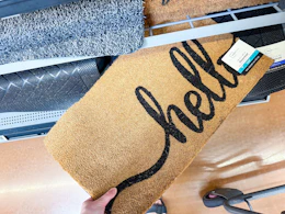 hand holding a mainstays coir doormat on walmart shelf