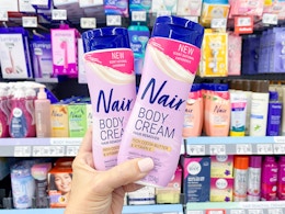 hand holding two bottles of Nair body cream