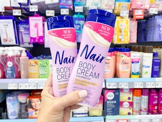 hand holding two bottles of Nair body cream