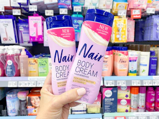 hand holding two bottles of nair body cream in walmart aisle