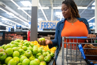 a woman shopping for fruit in walmart