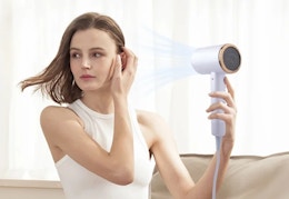 person holding an ionic hair dryer to dry her hair