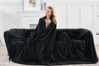 a woman on a couch under a blanket