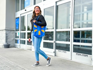 person walking out of Walmart with a Walmart reusable tote