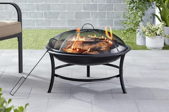 Walmart Mainstays outdoor fire pit being used in a backyard