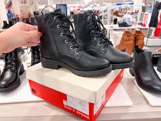 someone touching a black pair of women's combat boots