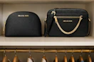 2 Michael Kors bags in closet shelf