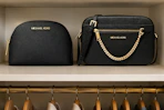 2 Michael Kors bags in closet shelf