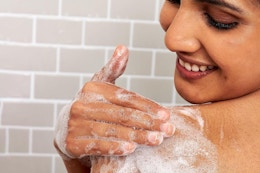 Aveeno Body Wash woman lathers her shoulder and smiles