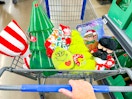 hand pushing a Walmart cart with Dollar Spot Holiday decorations in the front